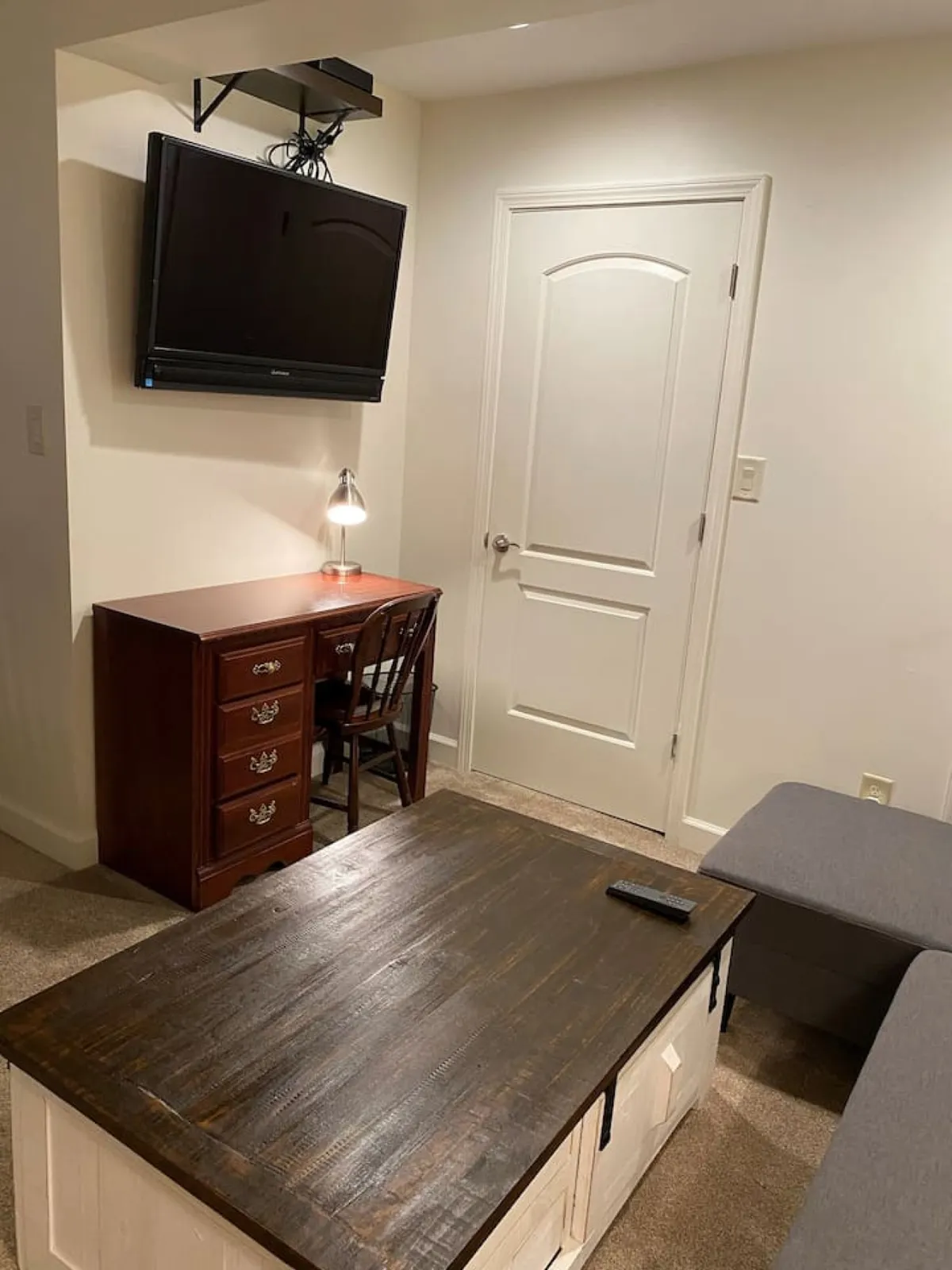 A cozy interior corner with a TV, a modern desk and chair, and a coffee table, suggesting a comfortable and functional environment just beyond the entrance—ideal for settling in as you arrive home.